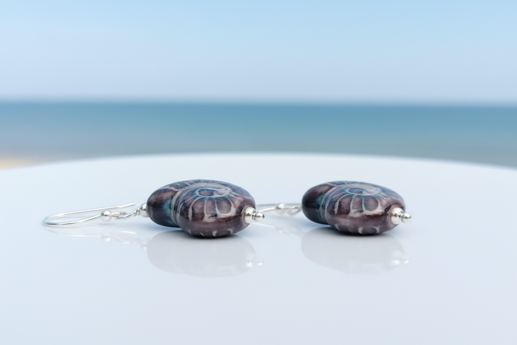 925 sterling silver ceramic nautilus shell drop earrings on coastal background